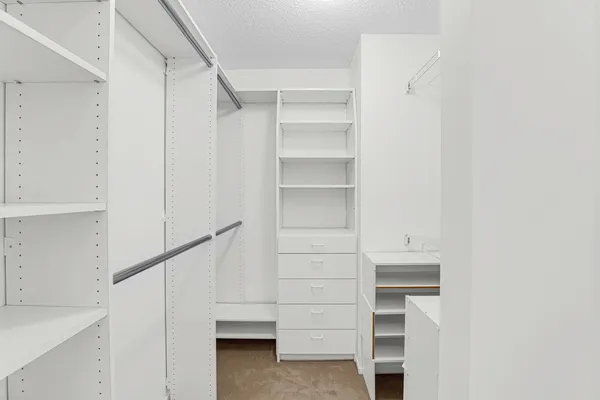 a view of walk in closet with empty racks