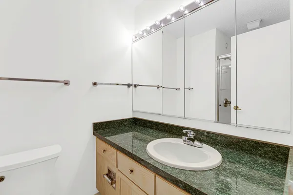 a bathroom with a granite countertop sink and a mirror