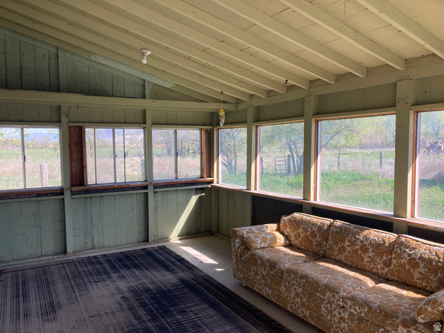 200 South 2800th Street West Ogden, UT 84404 - Photo 17 of 42 Sunroom / solarium with lofted ceiling, carpet floors, wood walls, and plenty of natural light
