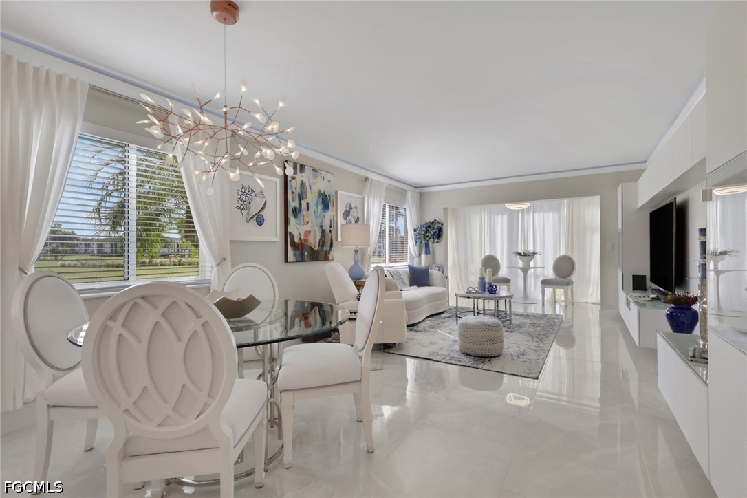 9 High Point Circle North, Unit 101 Naples, FL 34103 - Photo 5 of 49 a living room with furniture and a chandelier