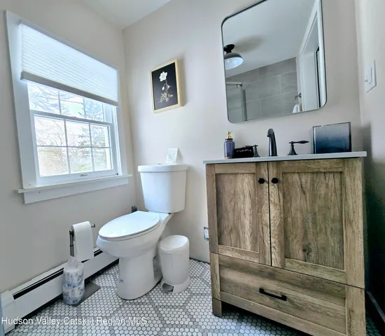 a bathroom with a sink a toilet and a mirror