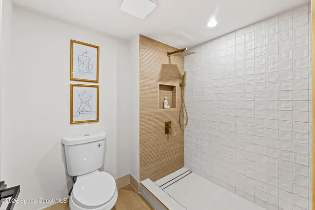 a bathroom with a toilet and a shower