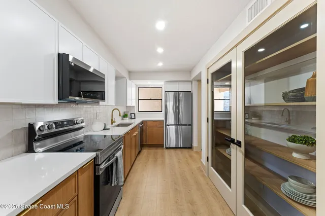 a kitchen with stainless steel appliances a refrigerator stove microwave and sink