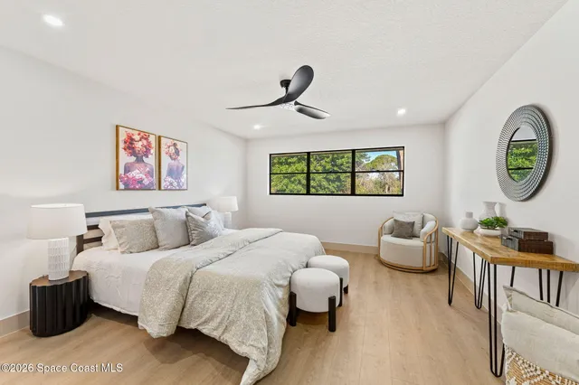 a bedroom with furniture and a large window