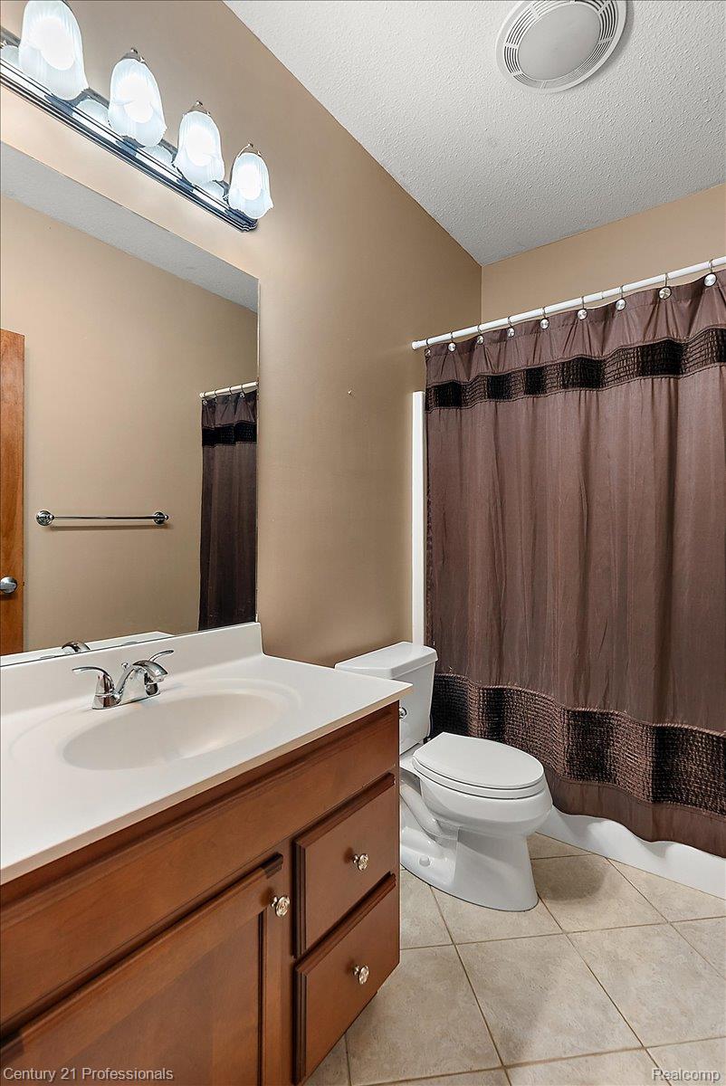 9867 Rainbow Ridge Drive Schoolcraft, MI 49087 - Photo 54 of 82 Bathroom featuring a wood-finish vanity with an integrated white sink, chrome fixtures, and a large wall mirror