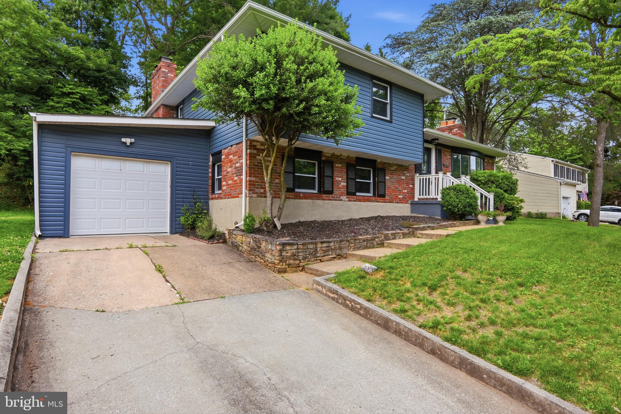 a front view of a house with a yard and potted plants