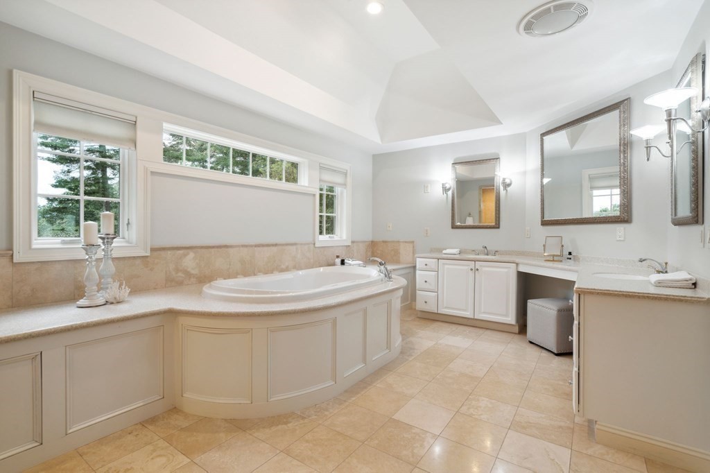 38 Pheasant Lane Manchester, NH 03109 - Photo 26 of 42 a bathroom with a granite countertop bathtub sink vanity and mirror