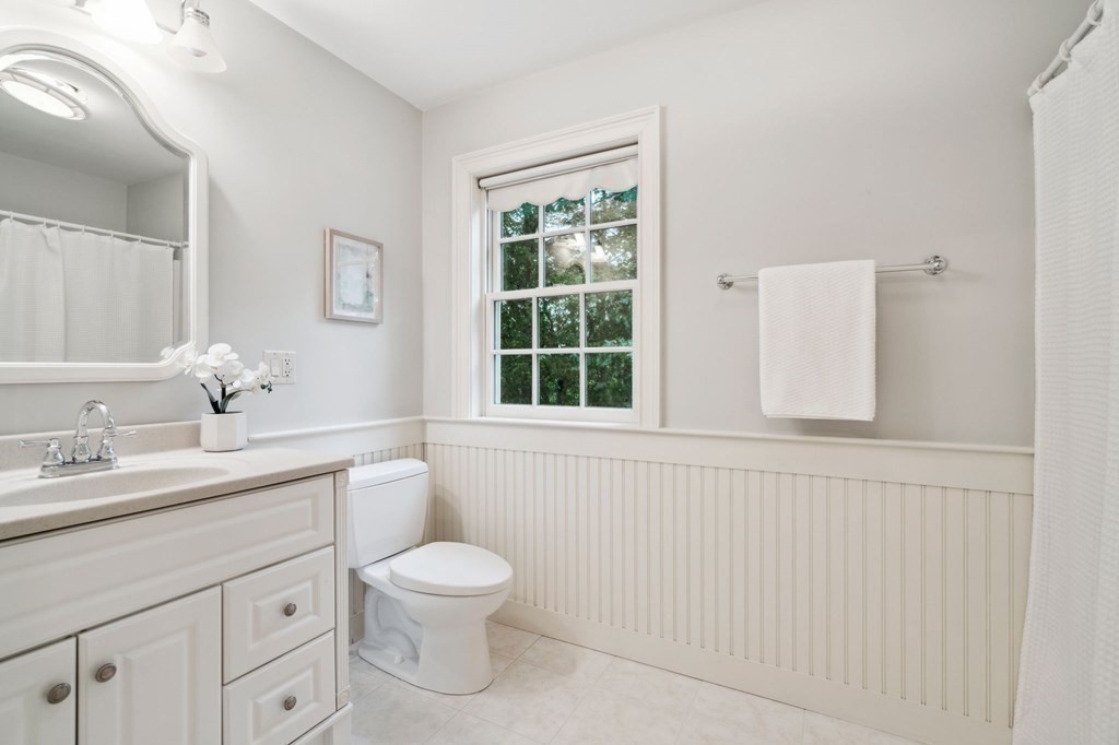 38 Pheasant Lane Manchester, NH 03109 - Photo 30 of 42 a bathroom with a toilet a sink a window and mirror