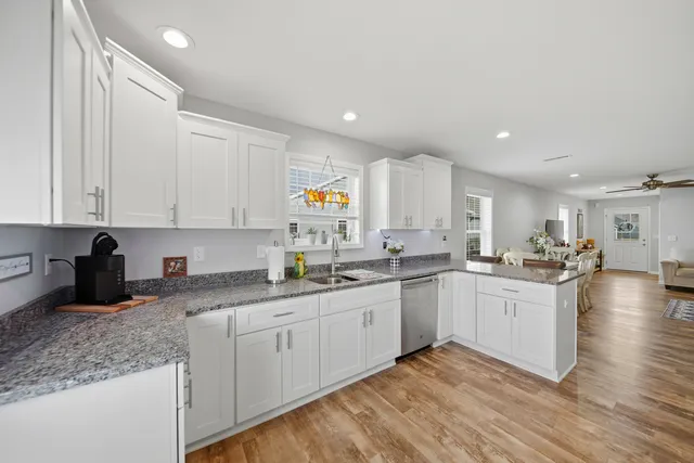 a kitchen with granite countertop a sink a stove and wooden cabinets