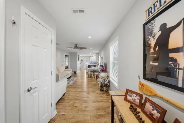 a view of a hallway with wooden floor and a livingroom