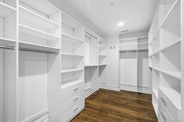 a view of walk in closet with empty racks