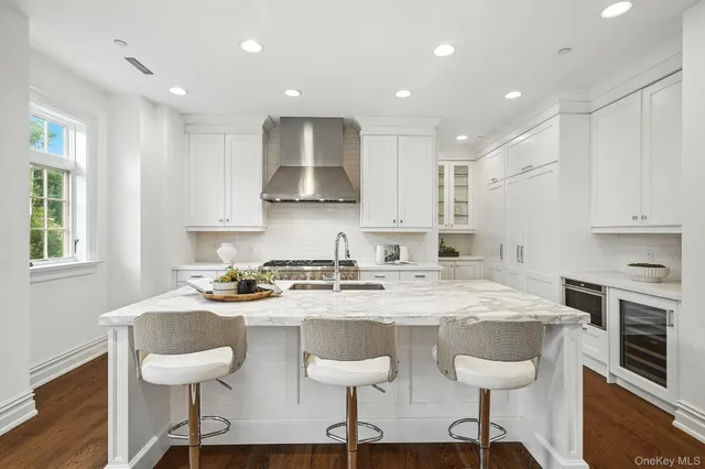 a kitchen with stainless steel appliances granite countertop a table chairs sink refrigerator and cabinets