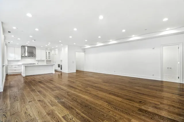 a view of kitchen with kitchen island wooden floor appliances and cabinets