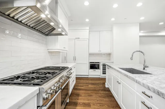 a kitchen with stainless steel appliances granite countertop a sink stove and cabinets
