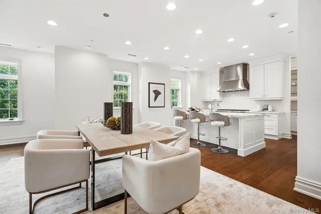 a living room with couches and kitchen view with wooden floor