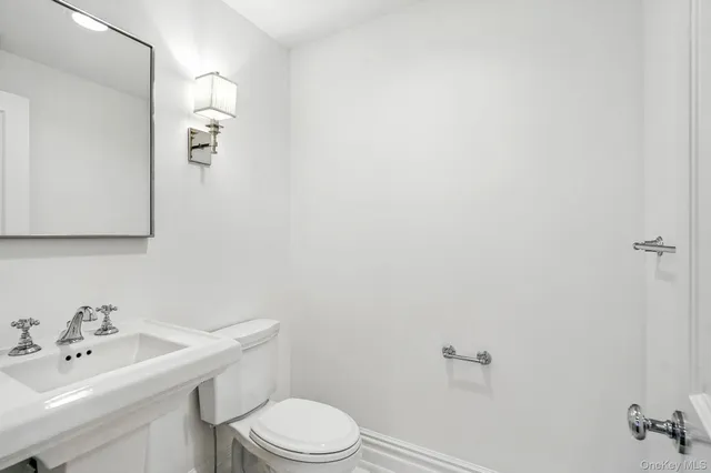 a bathroom with a toilet a sink and mirror