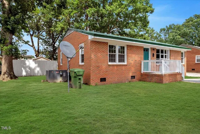 a front view of house with yard and trees in the background