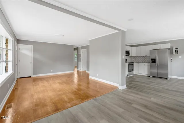 a view of empty room with wooden floor