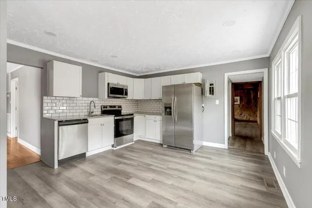 a kitchen with granite countertop a refrigerator and a stove top oven
