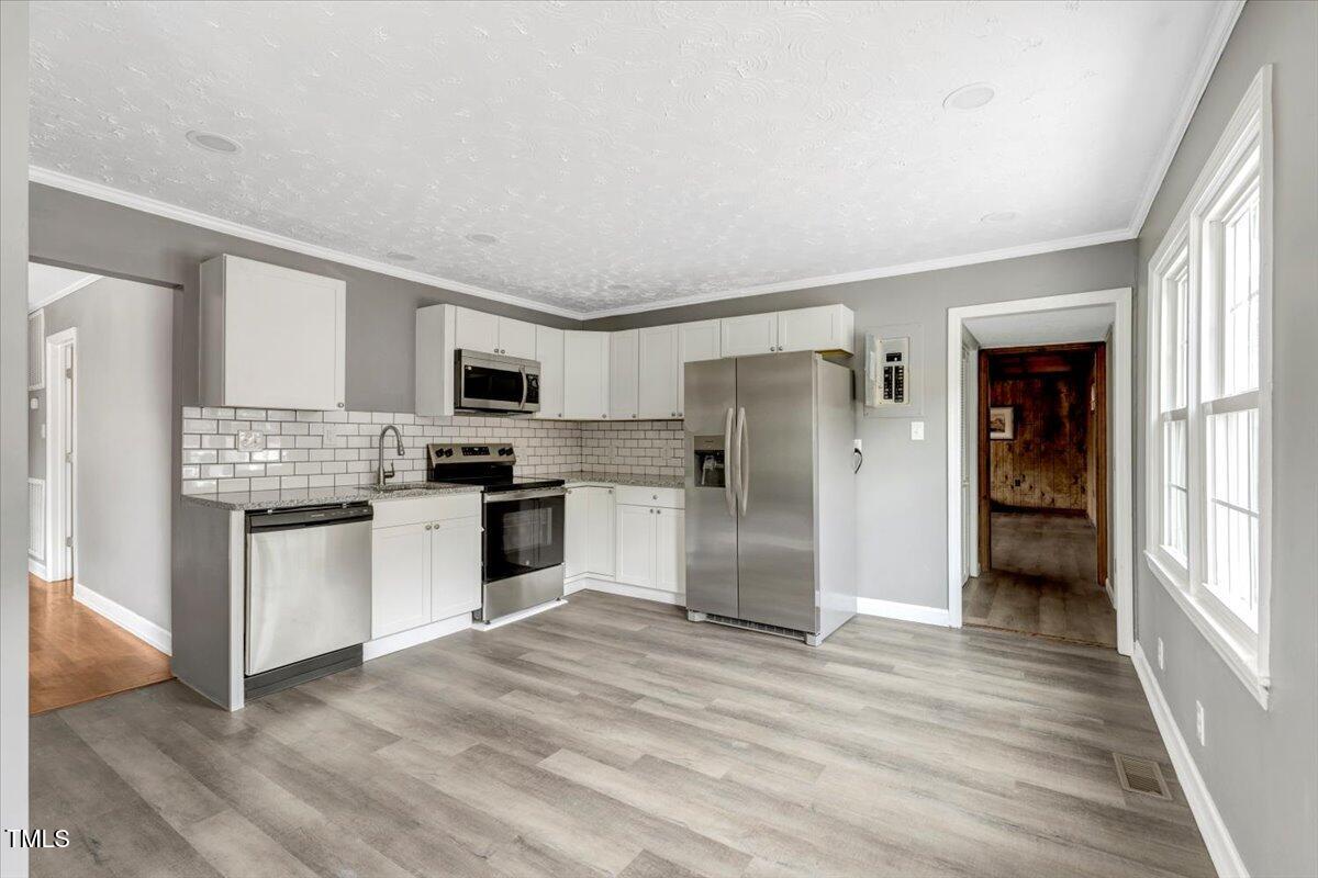 712 East 13th Street Roanoke Rapids, NC 27870 - Photo 18 of 46 a kitchen with granite countertop a refrigerator and a stove top oven