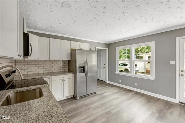 a kitchen with a refrigerator sink and wooden cabinets