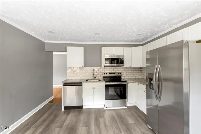 a kitchen with stainless steel appliances a refrigerator sink and stove