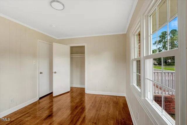 a view of a room with wooden floor and a window