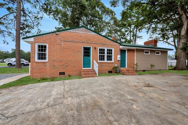 a backyard of a house with barbeque oven and trees