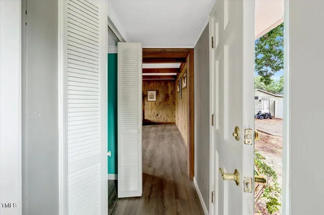 a view of a hallway with wooden floor and staircase