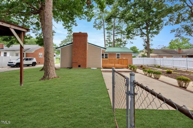 a view of a house with backyard and a tree