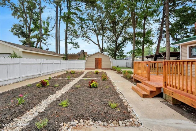a view of a yard with wooden fence