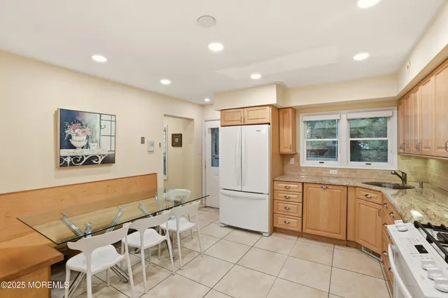 a large white kitchen with cabinets and a refrigerator