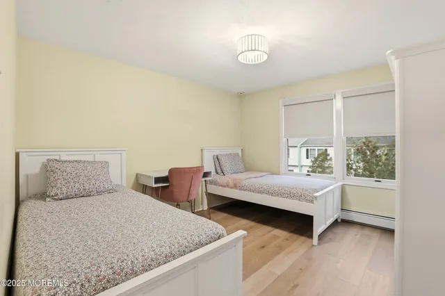 a bedroom with two beds and a large window