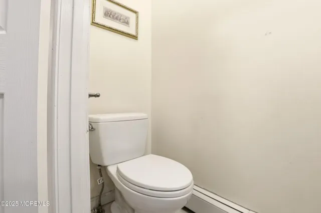 a white toilet sitting next to a white wall