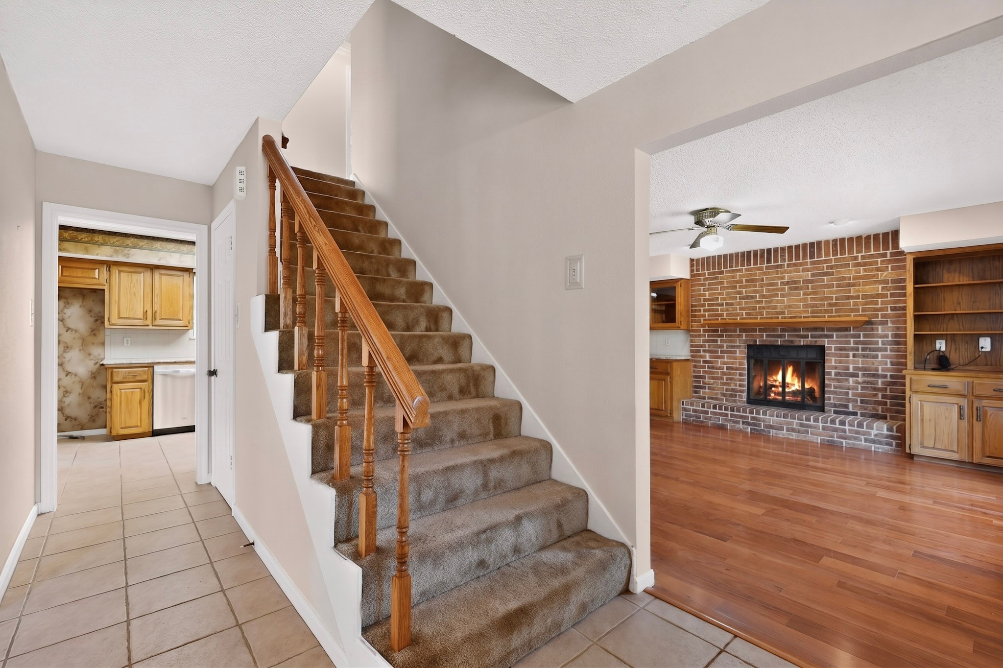 1003 Pier Branch Road Dripping Springs, TX 78620 - Photo 13 of 40 A warm fireplace radiates comfort in this living area, featuring an open staircase leading to the upper level.