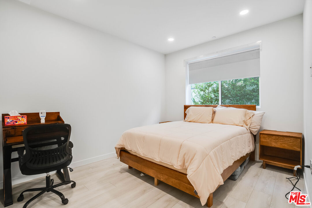 1021 South Shenandoah Street, Unit 101 Los Angeles, CA 90035 - Photo 11 of 18 a bedroom with a bed a desk and chair