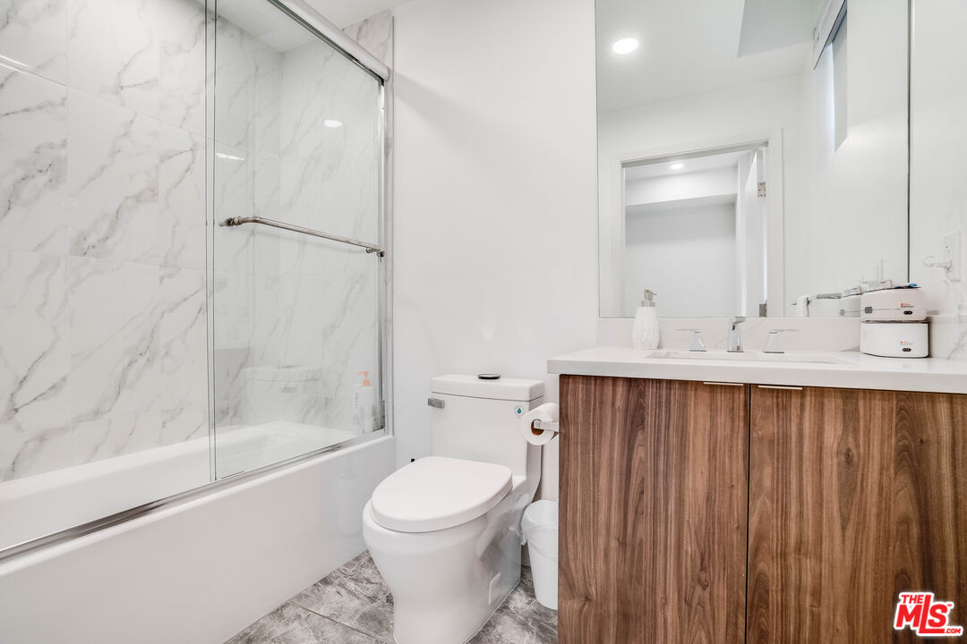 1021 South Shenandoah Street, Unit 101 Los Angeles, CA 90035 - Photo 14 of 18 a bathroom with a sink a toilet and shower