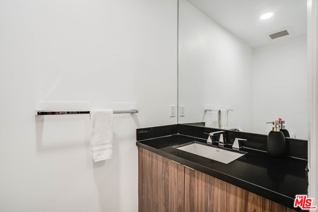 1021 South Shenandoah Street, Unit 101 Los Angeles, CA 90035 - Photo 15 of 18 a close view of sink and mirror