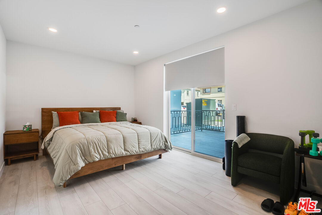 1021 South Shenandoah Street, Unit 101 Los Angeles, CA 90035 - Photo 7 of 18 a bedroom with a bed and wooden floor