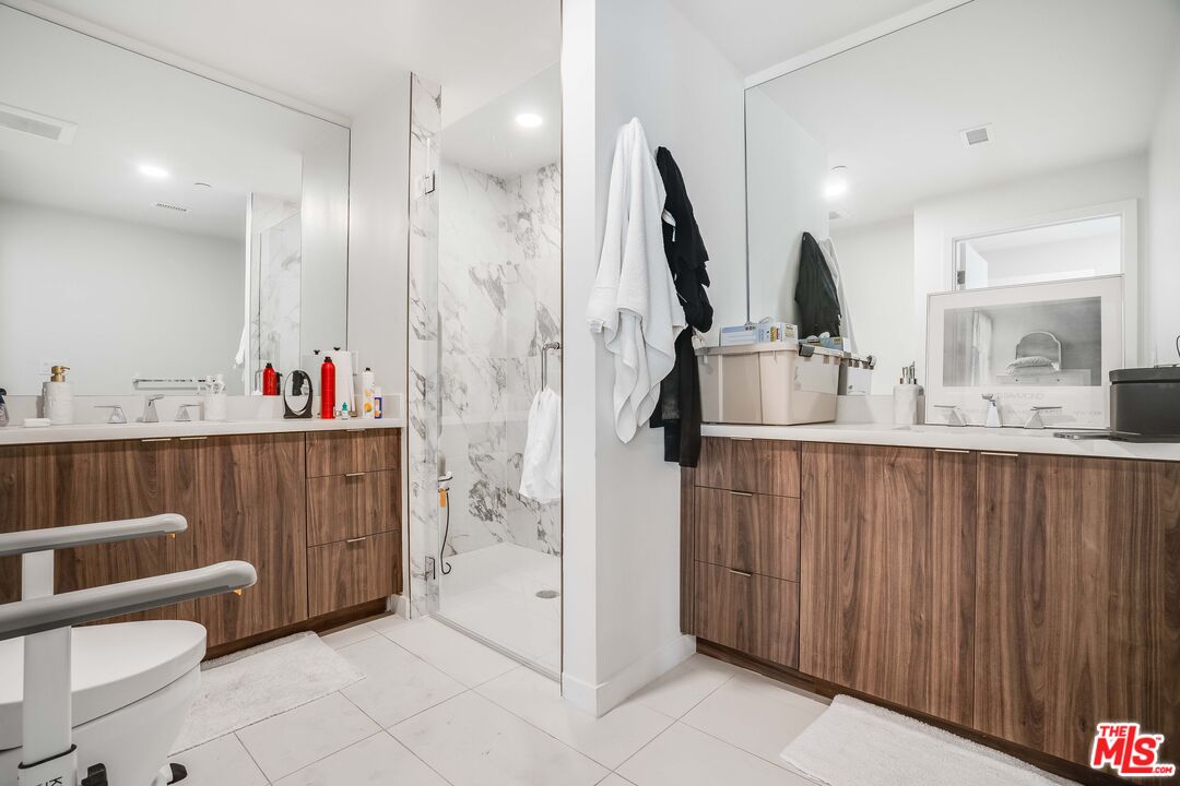 1021 South Shenandoah Street, Unit 101 Los Angeles, CA 90035 - Photo 9 of 18 a bathroom with a sink a toilet and a mirror