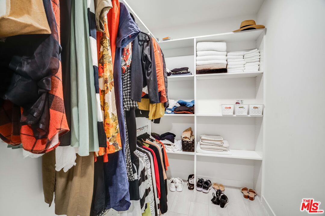 1021 South Shenandoah Street, Unit 101 Los Angeles, CA 90035 - Photo 10 of 18 a view of walk in closet with clothes and shoes