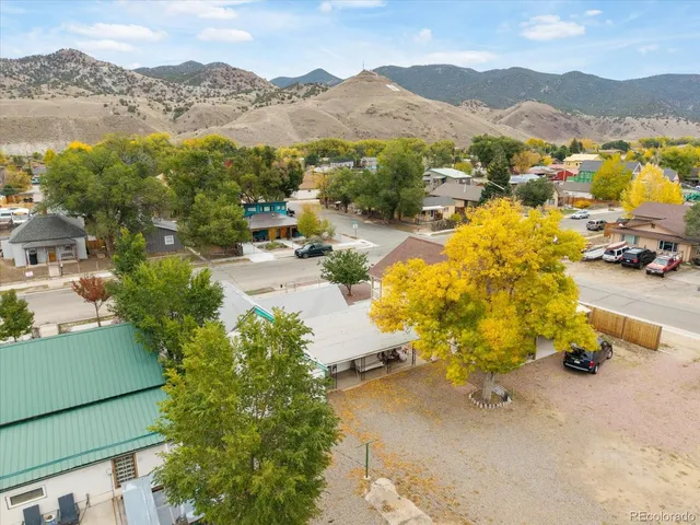 an aerial view of residential house with yard and mountain view