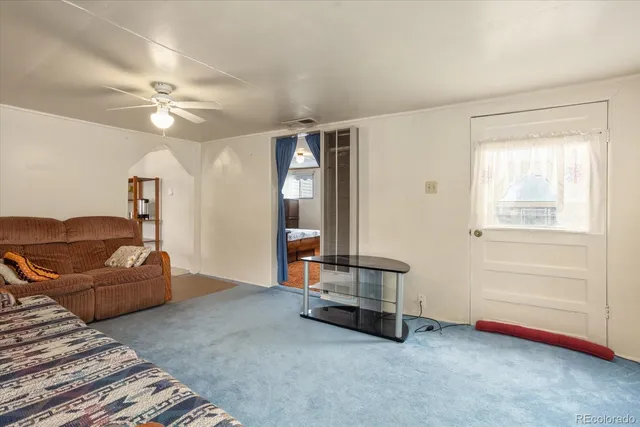 a living room with furniture and a ceiling fan