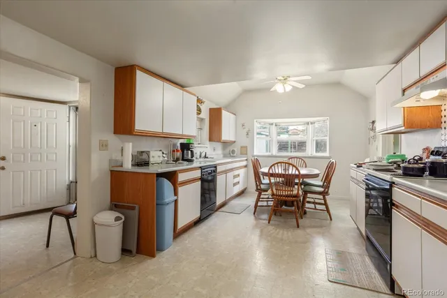 a kitchen with a table chairs microwave and cabinets