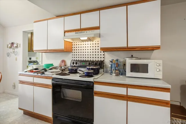 a kitchen with stainless steel appliances granite countertop a sink stove and microwave