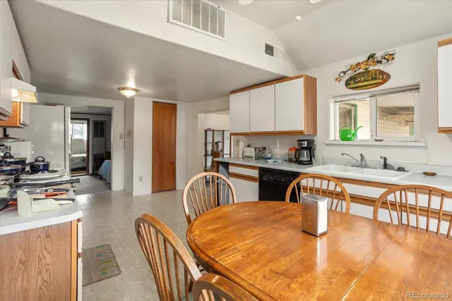a kitchen with stainless steel appliances granite countertop a sink a stove a dining table and chairs