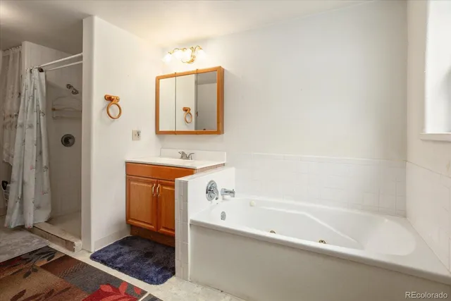 a bathroom with a bathtub a shower a sink and a mirror