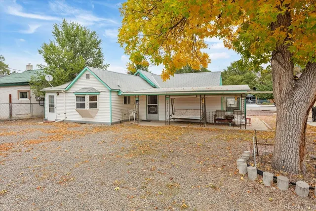 a front view of a house with a garden and trees