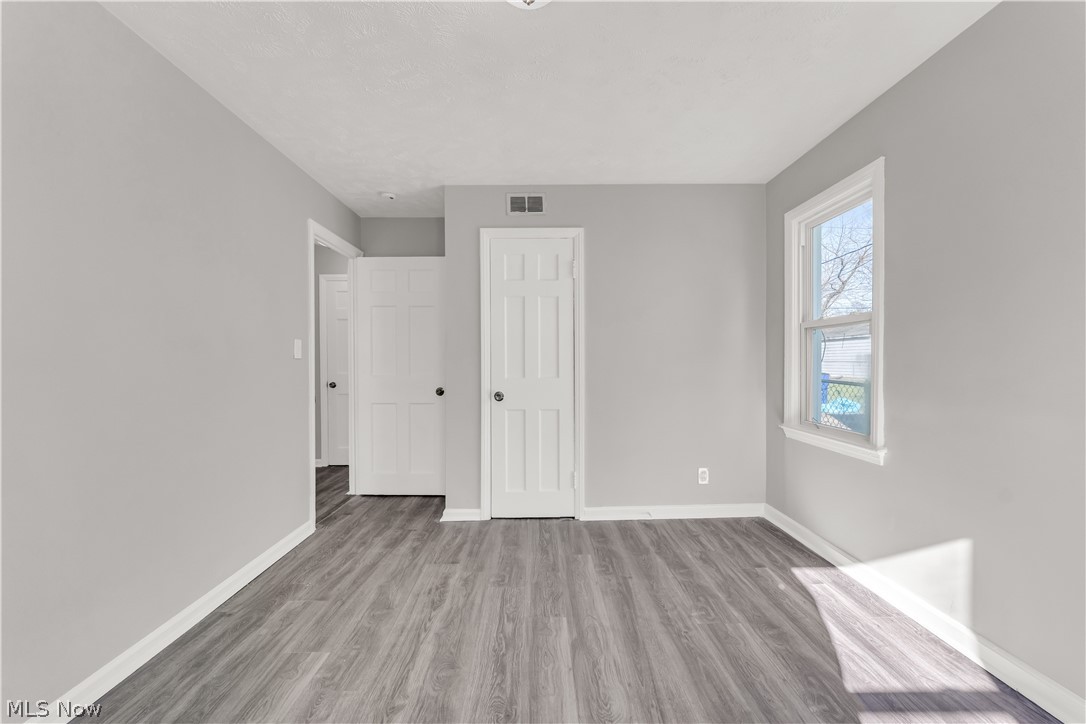 2521 Greenvale Road Cleveland, OH 44121 - Photo 13 of 23 Room featuring wood-finish flooring, light grey painted walls, white baseboards, and a white interior door