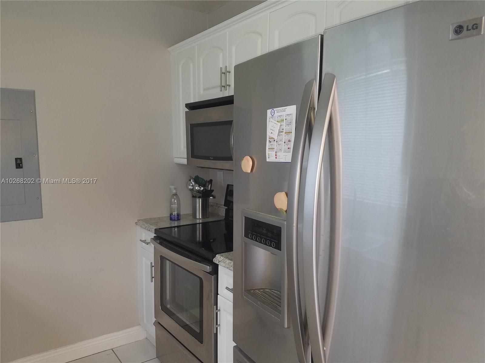 3091 Southwest 84th Court Miami, FL 33155 - Photo 11 of 24 a kitchen with stainless steel appliances granite countertop white cabinets and refrigerator